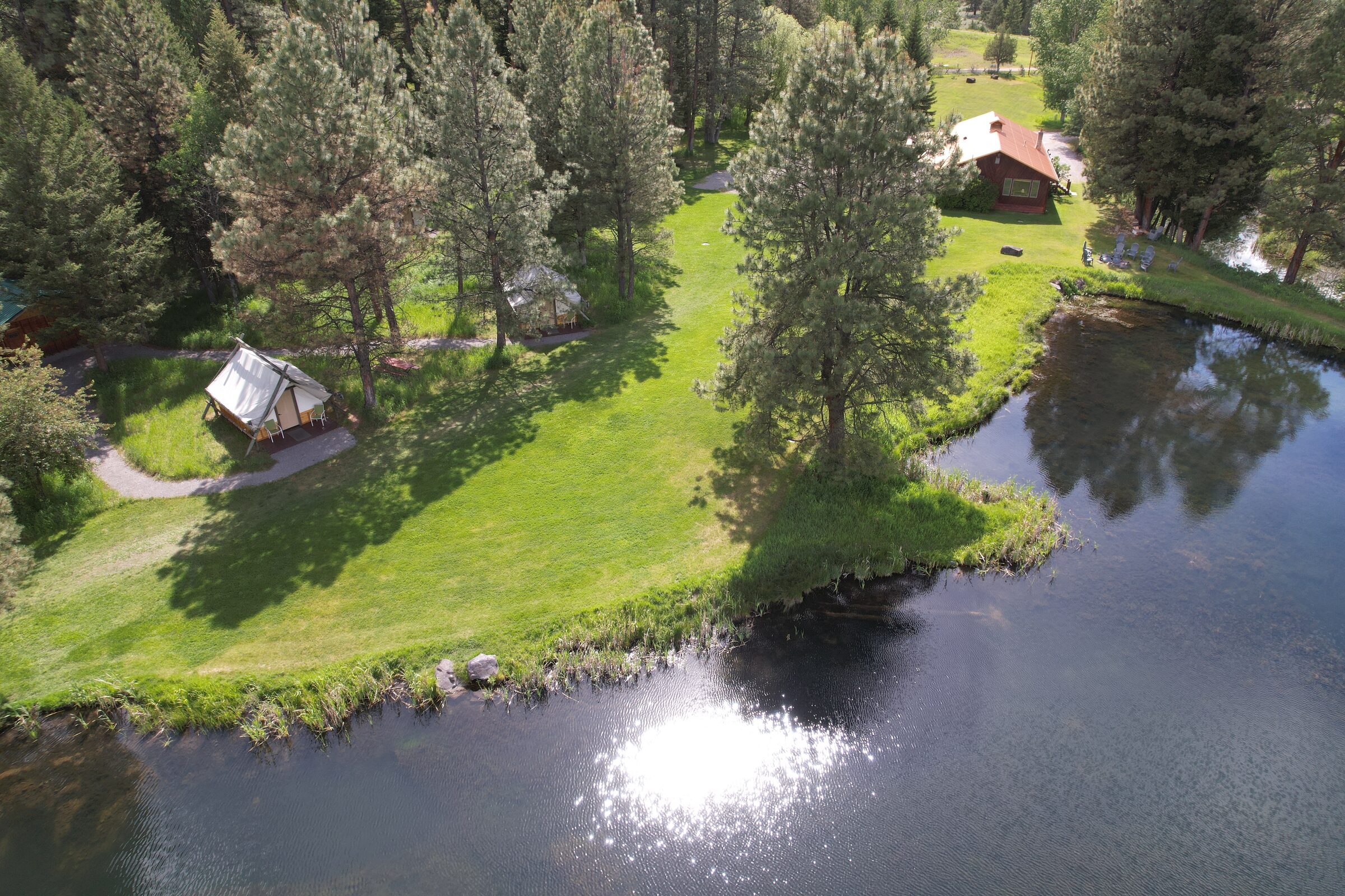 Tent cabins and the lodge above an artesian-fed pond