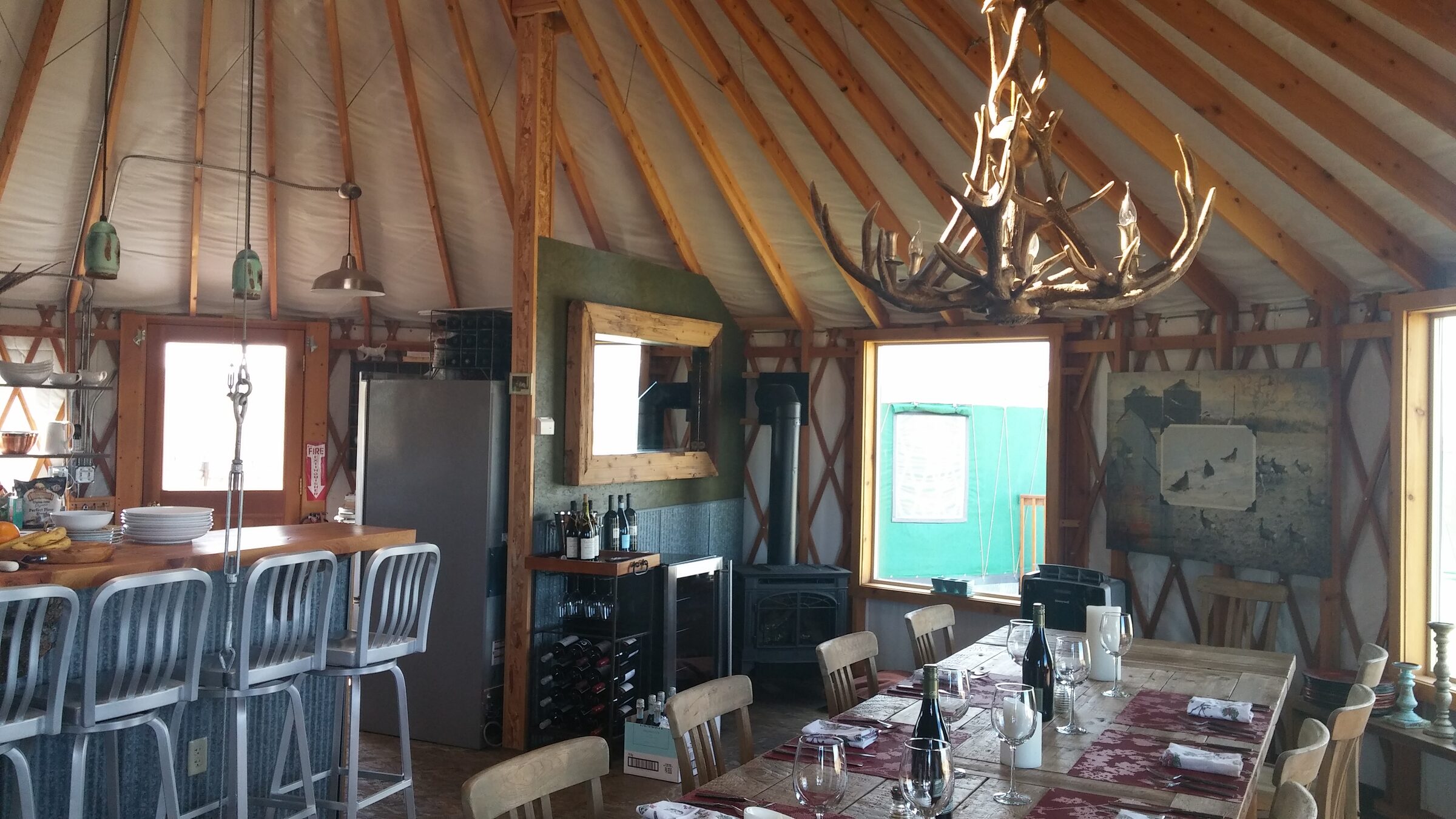 The dining yurt, with its long table and antler chandelier