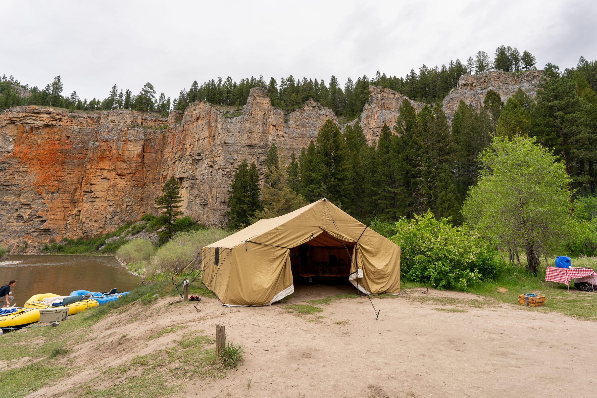The cook tent at camp beneath a red-streaked canyon wall
